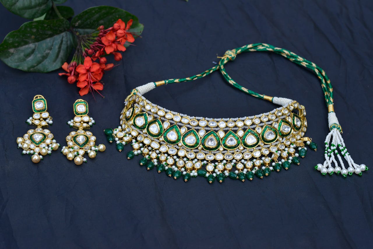 Elegant necklace and earring set with vibrant flowers on a blue background, perfect for festive attire.