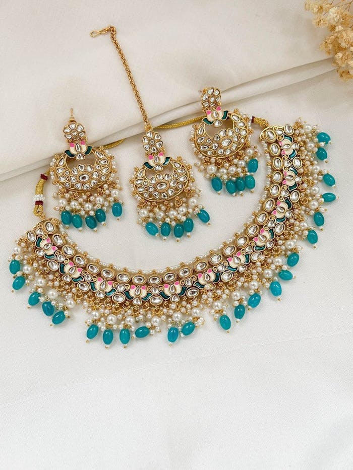 Elegant traditional Kundan necklace and earrings set with blue gemstones, perfect for cultural events.